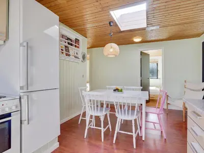 a kitchen and dining room with a white table and chairs at Holiday Home Ludde - 500m to the fjord by Interhome in Løgstør