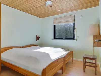 a bedroom with a large bed with a wooden ceiling at Holiday Home Ludde - 500m to the fjord by Interhome in Løgstør