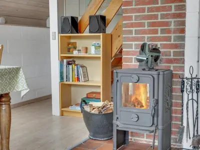 a fireplace in a living room with a brick wall at Holiday Home Valo - 400m to the fjord by Interhome in Løgsted
