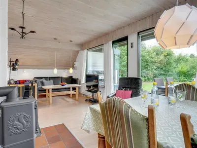 a living room with a table and a stove at Holiday Home Valo - 400m to the fjord by Interhome in Løgsted