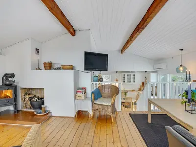 a living room with a table and a fireplace at Holiday Home Freda - 100m to the fjord by Interhome in Løgsted