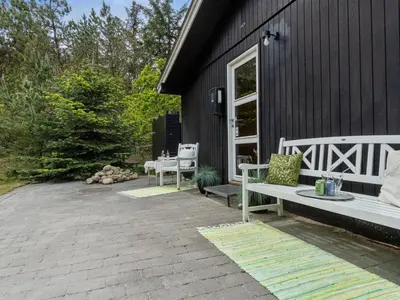 a bench sitting on a patio next to a house at Holiday Home Freda - 100m to the fjord by Interhome in Løgsted