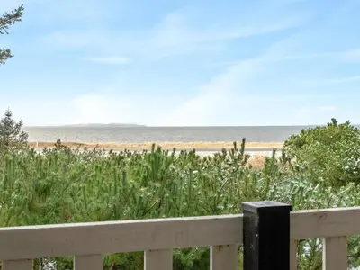 a view of the beach from a white fence at Holiday Home Freda - 100m to the fjord by Interhome in Løgsted