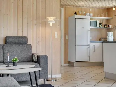 a kitchen with a chair and a table and a refrigerator at Holiday Home Wilja - 400m from the sea by Interhome in Fjerritslev