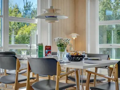 a dining room with a white table and chairs at Holiday Home Wilja - 400m from the sea by Interhome in Fjerritslev