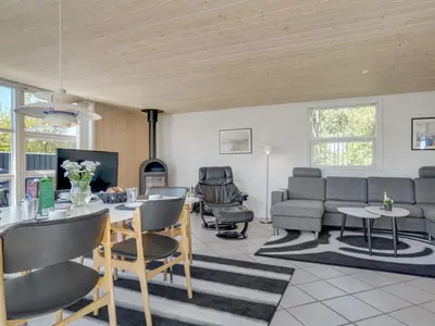 a living room with a table and a couch at Holiday Home Wilja - 400m from the sea by Interhome in Fjerritslev