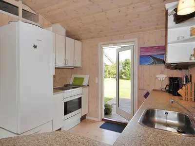 a kitchen with white appliances and a door to a yard at Holiday Home Einette - 3-5km from the sea by Interhome in Fjerritslev