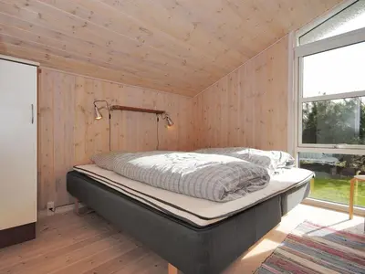 a bedroom with a bed in a wooden wall at Holiday Home Einette - 3-5km from the sea by Interhome in Fjerritslev