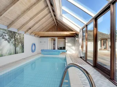 an indoor swimming pool with a roof with windows at Holiday Home Waldar - 900m from the sea by Interhome in Fjerritslev