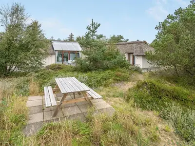 a wooden picnic table sitting on top of a field at Holiday Home Waldar - 900m from the sea by Interhome in Fjerritslev