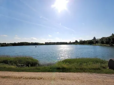 a large lake with the sun shining on the water at Holiday Home Alvira - 8km to the fjord by Interhome in Fjerritslev