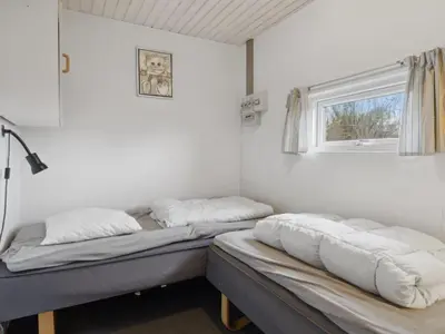 two beds in a room with a window at Holiday Home Justine - 600m from the sea by Interhome in Fjerritslev