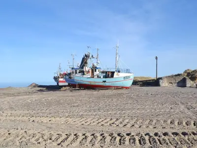 two boats sitting on the sand on a beach at Holiday Home Sighbiorn - 950m from the sea by Interhome in Fjerritslev