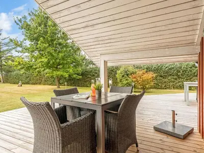 a patio with a table and chairs on a deck at Holiday Home Thurir - 4km from the sea by Interhome in Fjerritslev