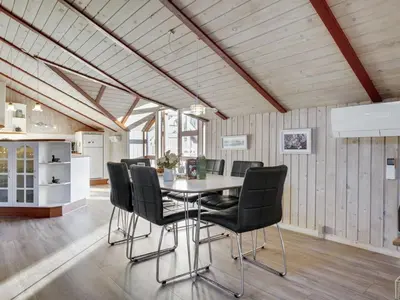a dining room with a table and black chairs at Holiday Home Thurir - 4km from the sea by Interhome in Fjerritslev