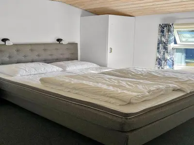 a large bed sitting in a bedroom next to a window at Holiday Home Ordan - 800m from the sea by Interhome in Fjerritslev