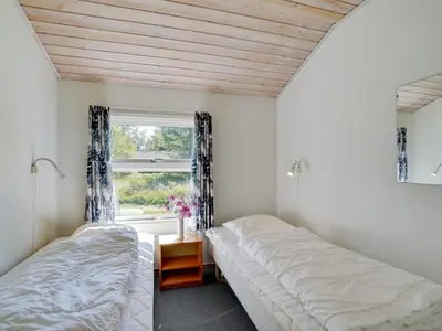 two beds in a room with a window at Holiday Home Ordan - 800m from the sea by Interhome in Fjerritslev
