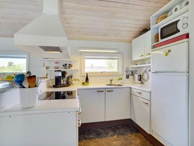 a kitchen with white cabinets and a white refrigerator at Holiday Home Ordan - 800m from the sea by Interhome in Fjerritslev