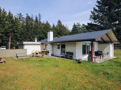 a small white house with a patio and a yard at Holiday Home Oberon - 3km from the sea by Interhome in Fjerritslev