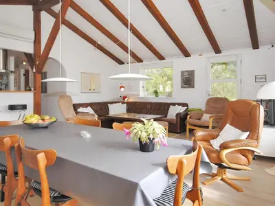a dining room and living room with a table and chairs at Holiday Home Oberon - 3km from the sea by Interhome in Fjerritslev