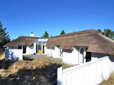 two thatched cottages with a white fence at Holiday Home Roulf - 1-1km from the sea by Interhome in Fjerritslev