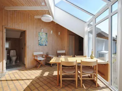 a room with a table and chairs and a toilet at Holiday Home Roulf - 1-1km from the sea by Interhome in Fjerritslev