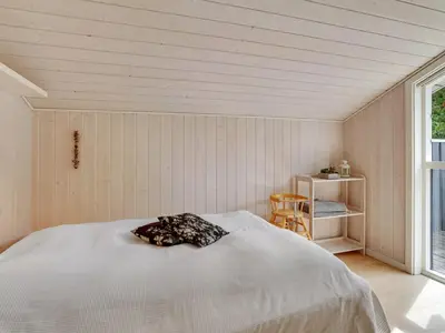 a bedroom with a bed in a room with a window at Holiday Home Gothfred - 1km from the sea by Interhome in Fjerritslev