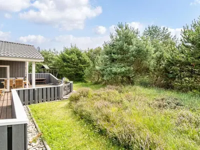 a backyard with a deck and a yard with grass at Holiday Home Gothfred - 1km from the sea by Interhome in Fjerritslev