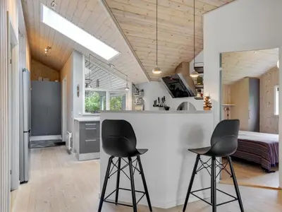 two black bar stools in a kitchen with a bed at Holiday Home Grimi - 4km from the sea by Interhome in Fjerritslev