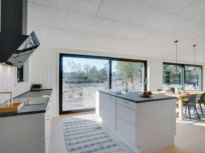 a kitchen with white cabinets and a large window at Holiday Home Vigga - 800m from the sea by Interhome in Fjerritslev