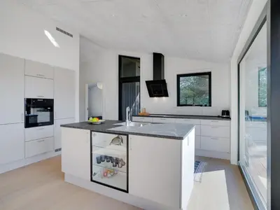 a kitchen with white cabinets and a counter top at Holiday Home Vigga - 800m from the sea by Interhome in Fjerritslev
