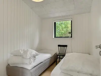 a bedroom with two beds and a window at Holiday Home Vigga - 800m from the sea by Interhome in Fjerritslev
