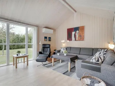 a living room with a couch and a chair at Holiday Home Henriete - 3-5km from the sea by Interhome in Fjerritslev