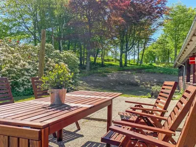 a wooden table and chairs on a patio at Holiday Home Nella - 1-2km from the sea by Interhome in Fjerritslev