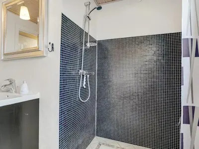 a bathroom with a shower with blue tiles at Holiday Home Swipdagh - 600m from the sea by Interhome in Fjerritslev