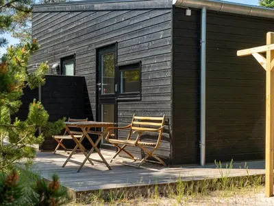 a cabin with two chairs and a table on a deck at Holiday Home Gunnor - 1-3km from the sea by Interhome in Fjerritslev
