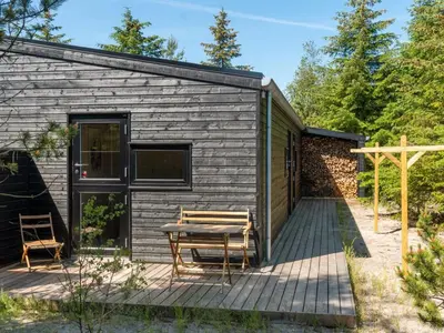 a cabin with a table and chairs on a deck at Holiday Home Gunnor - 1-3km from the sea by Interhome in Fjerritslev