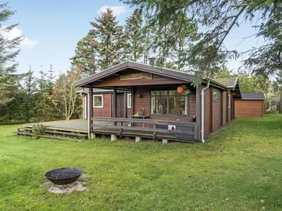 a small cabin with a deck in a yard at Holiday Home Artur - 1-5km from the sea by Interhome in Fjerritslev