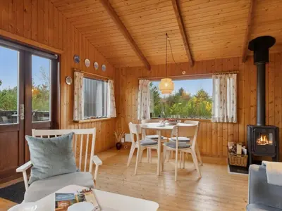 a room with a table and chairs and a fireplace at Holiday Home Asmo - 350m from the sea by Interhome in Fjerritslev