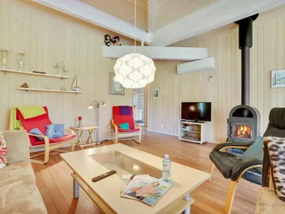 a living room with a table and a fireplace at Holiday Home Els - 900m from the sea by Interhome in Fjerritslev