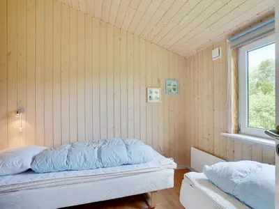 a small bedroom with a bed and a window at Holiday Home Els - 900m from the sea by Interhome in Fjerritslev