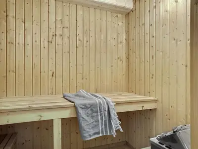 a wooden sauna with a towel sitting on a bench at Holiday Home Catarine - 1-1km from the sea by Interhome in Fjerritslev