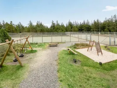 a park with a playground with a bench and a swing set at Holiday Home Catarine - 1-1km from the sea by Interhome in Fjerritslev