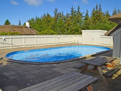 a swimming pool with a picnic table and a bench at Holiday Home Catarine - 1-1km from the sea by Interhome in Fjerritslev