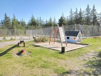 a playground with a slide and a house at Holiday Home Catarine - 1-1km from the sea by Interhome in Fjerritslev