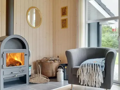 a living room with a chair and a fireplace at Holiday Home Frida - 700m from the sea by Interhome in Fjerritslev