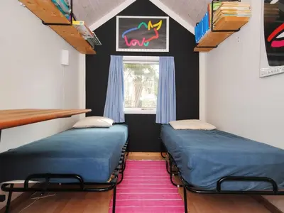 two beds in a room with a window and a pink rug at Holiday Home Deni - 4km from the sea by Interhome in Fjerritslev