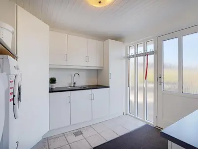 a kitchen with white cabinets and a window at Holiday Home Bitta - 500m from the sea by Interhome in Fjerritslev