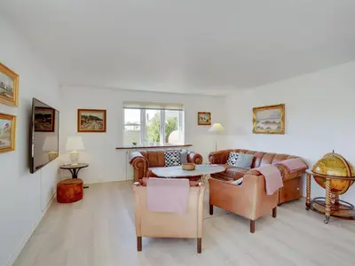 a living room with a couch and a table at Holiday Home Bitta - 500m from the sea by Interhome in Fjerritslev