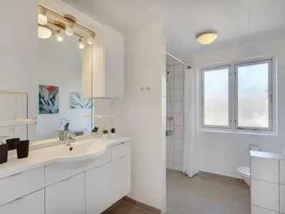 a white bathroom with a sink and a shower at Holiday Home Bitta - 500m from the sea by Interhome in Fjerritslev